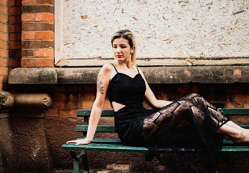clothing woman sits on green bench apparel